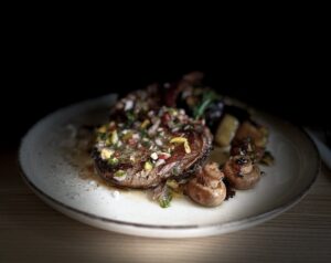 Vepřová kotleta Texas, restované brambory se žampiony, chimichurri omáčka